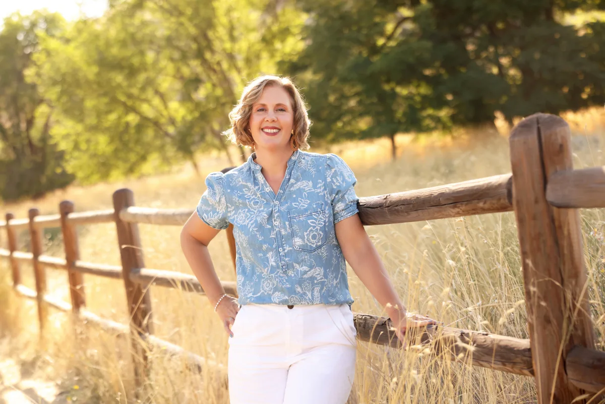 Preview of Cacey Klein smiling beside a wooden fence.