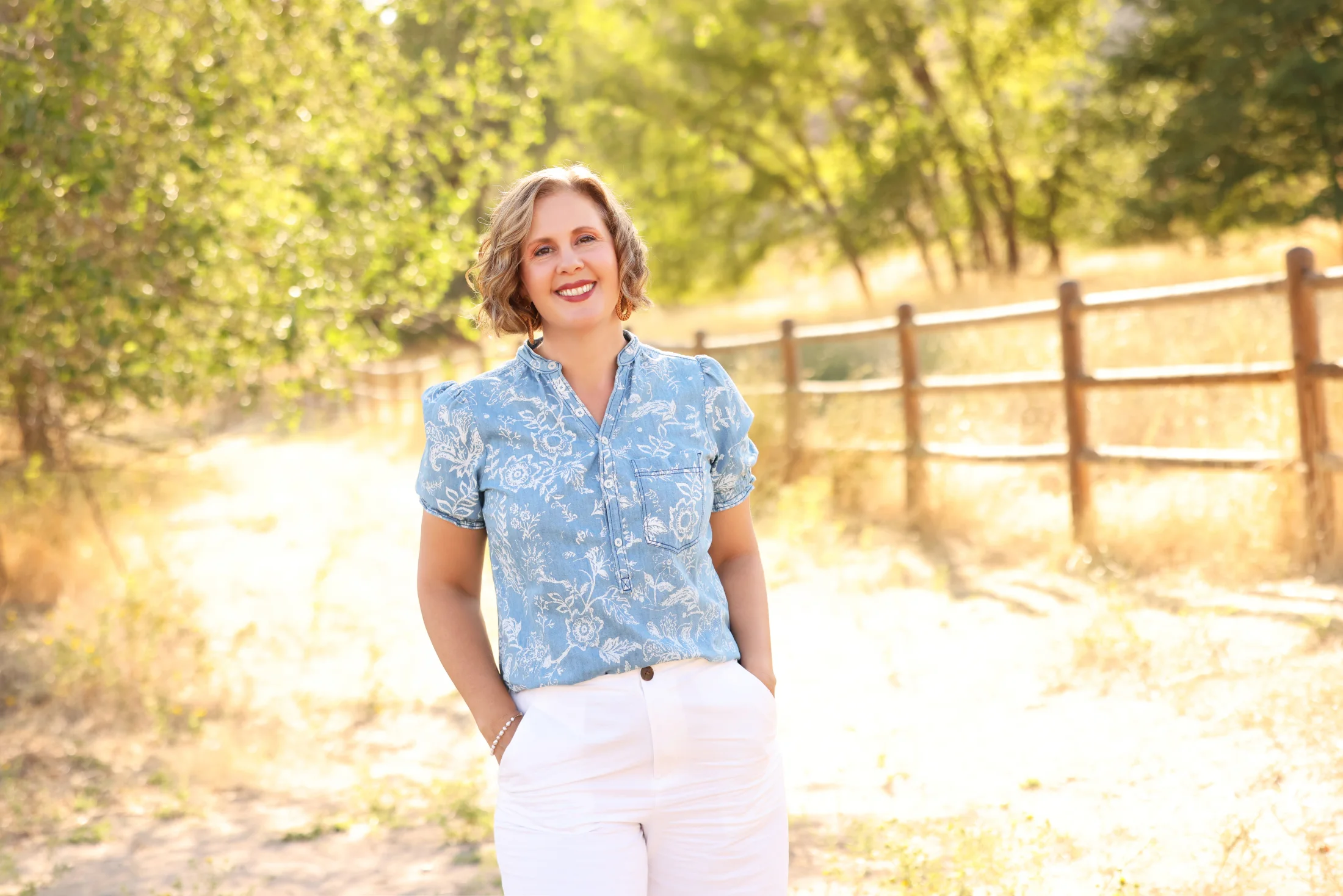 Cacey Klein standing on a tree-lined path in warm evening light.